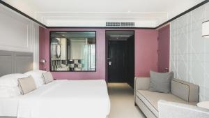 a bedroom with a white bed and a couch at Sugar Marina Hotel - FASHION - Kata Beach in Kata Beach