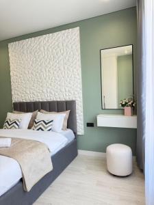a bedroom with a large bed and a mirror at Двухкомнатная квартира с дизайнерским интерьером и видом на горы in Almaty