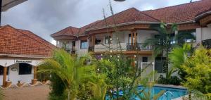 a house with a swimming pool in front of it at Mowicribs Hotel and Spa in Entebbe