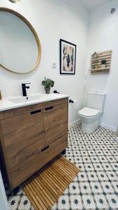 a bathroom with a sink and a mirror and a toilet at Casa en el centro , con amplia terraza in Vinarós