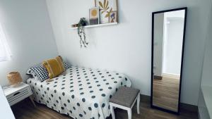 a small bedroom with a bed and a mirror at Casa en el centro , con amplia terraza in Vinarós