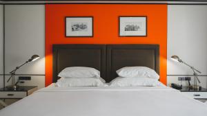 a bed with two pillows and an orange wall at Sugar Marina Hotel - FASHION - Kata Beach in Kata Beach