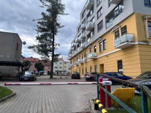 un estacionamiento con autos estacionados al lado de un edificio en Palace Hill Poprad, en Poprad