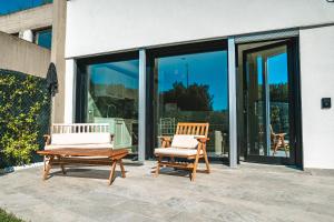 twee stoelen op een patio voor een gebouw bij Be Your Home - Il Piccolo Paradiso in Civitavecchia