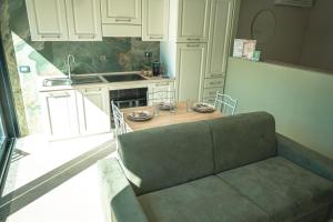 een keuken met een bank en een tafel. bij Be Your Home - Il Piccolo Paradiso in Civitavecchia