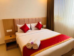 a hotel room with a bed with towels on it at Mountain Pass Residency in Edakkara