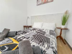 a bedroom with a bed with a black and white blanket at Appartement 2 chambres - Arrivée autonome - Wi-Fi Fibre in Bruay-la-Buissiere