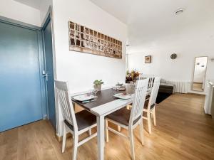 a dining room with a white table and chairs at Appartement 2 chambres - Arrivée autonome - Wi-Fi Fibre in Bruay-la-Buissiere