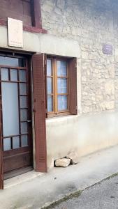 a building with a door and a rock on the sidewalk at Gîte La Giroflee in Meillonnas