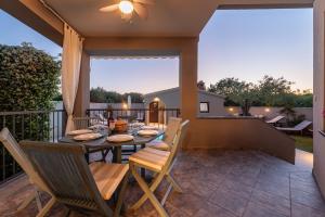 patio ze stołem i krzesłami na balkonie w obiekcie Villa Antea ZadarVillas w mieście Zadar