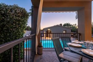 stół na balkonie z widokiem na basen w obiekcie Villa Antea ZadarVillas w mieście Zadar