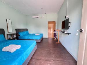 a room with two beds and a flat screen tv at Avina's Family Room in Setiu