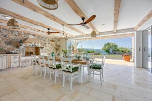 a kitchen and dining room with a table and chairs at VILLA PRISUNAC - private luxury with amazing sea view between Istria and Kvarner in Zagorje