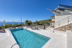a villa with a swimming pool and a house at VILLA PRISUNAC - private luxury with amazing sea view between Istria and Kvarner in Zagorje