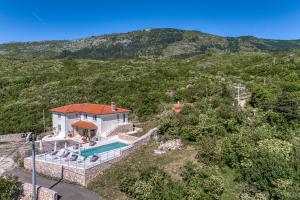 an aerial view of a house with a swimming pool at VILLA PRISUNAC - private luxury with amazing sea view between Istria and Kvarner in Zagorje