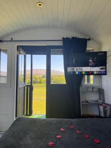 a bedroom with a bed with a television and a window at Little lake lodge faceboo in Armoy