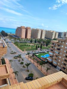 a city street with palm trees and buildings and the ocean at Apartamento Lyz y Mar en Magic World in Oropesa del Mar