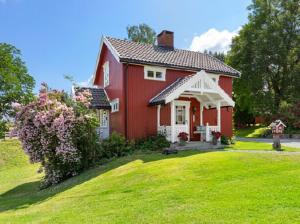 a red house with a green lawn in front of it at Landlig og Idyllisk in Sylling