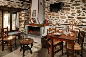 a living room with a table and a fireplace at Archontiko Michael since 1868 in Vyzitsa
