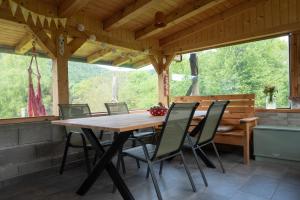 a wooden table and chairs in a screened in porch at Deer Land Photo Apartment in Kočevska Reka