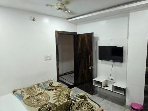 a bedroom with a bed and a flat screen tv at Hotel RB Palace in Indore +11 photos
