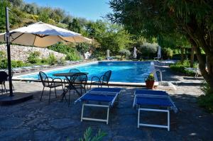 a pool with tables and chairs and an umbrella at Casa Camillo Piana Ovest in Lerici