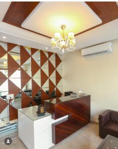 sala de estar con techo con lámpara de araña en The venture, en Zirakpur
