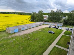an aerial view of a building with cars parked in a field at Möbliert Wohnen in Weickelsdorf in Bahnhof Weickelsdorf
