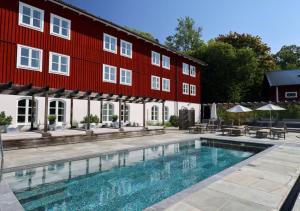 a swimming pool in front of a red building at Skytteholm in Ekerö