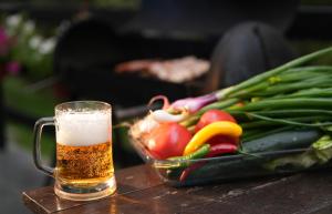 a glass of beer next to a bowl of vegetables at Mladenović Kuća in Kopaonik +37 photos