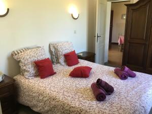 a bed with purple and red pillows on it at La maison du bonheur in Milhac