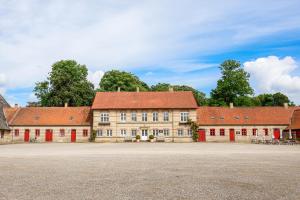 a large building with red roofs on a street at Lundsgaard Gods ferielejlighed in Kerteminde