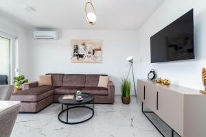 a living room with a couch and a table at Natura Vita Apartment-New Modern Apartment with City View & two Free Parking Spaces-10 min Walk to Trogir Old Town in Trogir