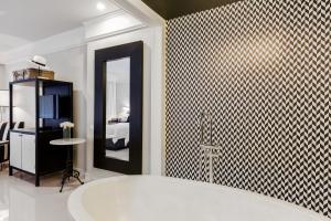 a bath tub in a bathroom with a tiled wall at Sugar Marina Hotel - FASHION - Kata Beach in Kata Beach