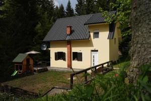 a house with a black roof and a yard at Mladenović Kuća in Kopaonik