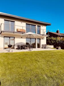 a large white house with an umbrella and a lawn at Ferienhaus Auszeit in Laubach +16 photos