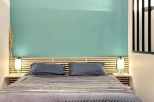 a bedroom with a large bed with two blue walls at Loft Carré d'or - Wifi, climatisation, 4 personnes in Nice