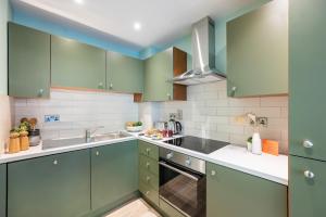 a kitchen with green cabinets and a sink at Staycity Aparthotels Dublin Augustine in Dublin