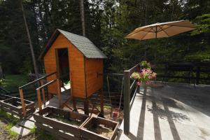 a small wooden house with an umbrella on the steps at Mladenović Kuća in Kopaonik
