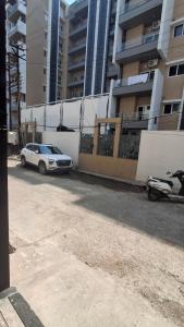 une voiture blanche garée devant un immeuble dans l'établissement Mrityunjay Yogpeeth, à Jāmb