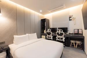 a bedroom with a bed and a desk with chairs at Giverny Hotel in Gyeongju +74 photos