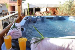 a hot tub on a balcony with two glasses of orange juice at Riad Léna & Spa in Marrakech