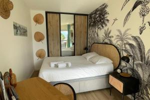 une petite chambre avec un lit avec un miroir dans l'établissement Le Port Camargue - 2 bedrooms air conditioning terrace and swimming pool!, au Grau-du-Roi