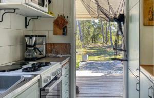 a kitchen with a stove and a door to a yard at 3 Bedroom Cozy Home In Tingstäde in Tingstäde