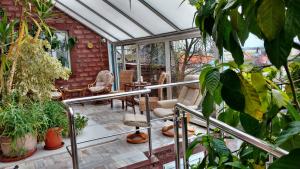 a conservatory with chairs and plants on a patio at Agroturystyka Gramburg in Zblewo