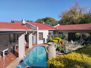 a swimming pool in the backyard of a house at Faerie Glen B&B in Pretoria