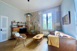 salon z kanapą i stołem w obiekcie Le Coeur de Ville - Charmant pour 2 personnes ! w Montpellier