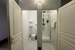 a bathroom with a toilet and a shower and a door at Le Magnan - Stone family home in Castries! in Castries +27 photos
