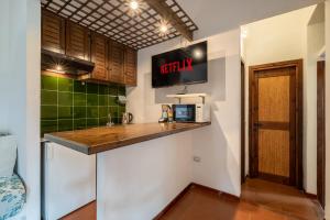 una cucina con bancone e TV a parete di 40mt dal Mare&Piscina- Casa Relax Vista Mare a Proiettore