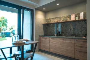 una cucina con un lavello e un tavolo con sedie di Be Your Home - Il Piccolo Paradiso a Civitavecchia